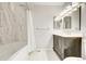 Updated bathroom features marble tile surround, modern vanity, and sleek lighting at 8418 Everett Way # C, Arvada, CO 80005