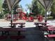 Community playground featuring vibrant red playground equipment with picnic tables available for outdoor gatherings at 8418 Everett Way # C, Arvada, CO 80005