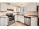 Updated kitchen with stainless steel appliances, light colored cabinets and window at 16755 E Union Ave, Aurora, CO 80015