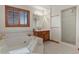 Bright bathroom features a soaking tub with tile surround, wood vanity, and walk-in shower at 937 Caribou Dr, Monument, CO 80132