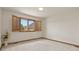 Empty bedroom featuring neutral carpet, a large shuttered window, and white walls at 937 Caribou Dr, Monument, CO 80132