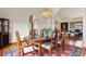 Formal dining room with a chandelier, hardwood floors, and a large glass table at 937 Caribou Dr, Monument, CO 80132