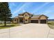 Inviting home with brick accents, three-car garage, and ample driveway space on a well-manicured lawn at 937 Caribou Dr, Monument, CO 80132