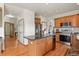 Open kitchen with island, hardwood floors, stainless steel appliances, and granite countertops at 937 Caribou Dr, Monument, CO 80132