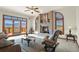 This living room features a brick fireplace, plush seating, ceiling fan, and deck access at 937 Caribou Dr, Monument, CO 80132