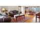 Elegant living room featuring hardwood floors, a leather sofa, and a view into the dining room at 937 Caribou Dr, Monument, CO 80132