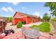 Private backyard features a charming red stamped concrete patio, a storage shed, and well-maintained landscaping at 5577 Jasper St, Denver, CO 80239