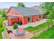 Exterior view showcasing a charming red house with a spacious yard and a private backyard patio at 5577 Jasper St, Denver, CO 80239