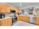 Stylish kitchen featuring wood cabinets, modern appliances, and tile backsplash at 5577 Jasper St, Denver, CO 80239
