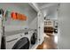 Convenient laundry room with modern washer and dryer, plus extra shelving for storage at 5577 Jasper St, Denver, CO 80239