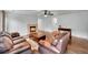 Cozy living room featuring a stone fireplace, hardwood floors, and comfortable leather seating at 5577 Jasper St, Denver, CO 80239