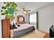 Comfortable carpeted bedroom featuring a ceiling fan, large window, and wooden dresser at 3355 S Flower St # 107, Lakewood, CO 80227