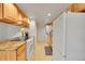 Well-lit kitchen with granite countertops, wood cabinets, white appliances, and convenient laundry area at 3355 S Flower St # 107, Lakewood, CO 80227