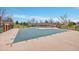 Outdoor pool with safety cover, brick fence, and a covered structure in the background at 3355 S Flower St # 107, Lakewood, CO 80227