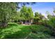 Expansive backyard showcases lush lawn, mature trees, inviting patio area, and manicured landscaping at 6300 E 17Th Avenue Pkwy, Denver, CO 80220