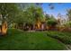 Expansive backyard features a brick patio, lush green lawn, mature trees, and charming landscaping details at 6300 E 17Th Avenue Pkwy, Denver, CO 80220