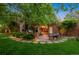 Lush backyard showcasing a brick patio with outdoor seating, garden area, and mature trees at 6300 E 17Th Avenue Pkwy, Denver, CO 80220