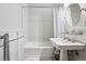 Clean and simple bathroom with a pedestal sink, tiled walls, and a shower with a curtain at 6300 E 17Th Avenue Pkwy, Denver, CO 80220