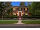 Charming two-story brick home featuring a well-manicured lawn, flower boxes and a red front door at 6300 E 17Th Avenue Pkwy, Denver, CO 80220