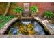 Picturesque koi pond with a waterfall feature, lush ferns, and decorative brickwork at 6300 E 17Th Avenue Pkwy, Denver, CO 80220