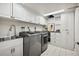 Modern laundry room equipped with front-loading washer/dryer, built-in cabinets, and stylish tiling at 6300 E 17Th Avenue Pkwy, Denver, CO 80220