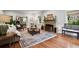 Inviting living room featuring a stone fireplace, hardwood floors, and large windows at 6300 E 17Th Avenue Pkwy, Denver, CO 80220
