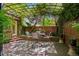 Cozy brick patio features a vine-covered pergola, an outdoor dining set, and a charming outdoor space at 6300 E 17Th Avenue Pkwy, Denver, CO 80220