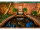 Charming outdoor pond with a waterfall feature, decorative stone lion head, and vibrant koi fish swimming below at 6300 E 17Th Avenue Pkwy, Denver, CO 80220
