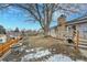 Backyard featuring a wooden deck, patio, large tree, and partial winter snow at 3863 S Bahama St, Aurora, CO 80013