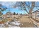 Backyard featuring a wooden deck, patio, large tree and partial winter snow at 3863 S Bahama St, Aurora, CO 80013
