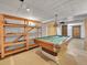 Unfinished basement featuring a pool table, wood shelving and a hanging light fixture at 3863 S Bahama St, Aurora, CO 80013
