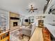 Relaxing living room featuring a brick fireplace, hardwood floors, and a view of the kitchen at 3863 S Bahama St, Aurora, CO 80013