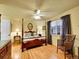 Bright main bedroom featuring hardwood floors, a four-poster bed, and natural light at 3863 S Bahama St, Aurora, CO 80013