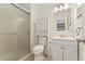 Bright bathroom featuring a shower, toilet, vanity and mirror with modern lighting at 1885 S Quebec Way # A28, Denver, CO 80231