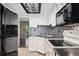 Well-lit kitchen with stainless steel appliances, white cabinetry, and modern backsplash at 1885 S Quebec Way # A28, Denver, CO 80231