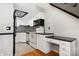 Updated kitchen with white cabinets, modern appliances, and black and white backsplash at 1885 S Quebec Way # A28, Denver, CO 80231