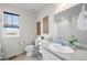 Bathroom featuring a vanity with a sink, toilet, a large mirror, and a window at 27674 E 7Th Dr, Aurora, CO 80018