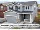Charming two-story home boasts a covered porch, attached garage, and inviting curb appeal at 27674 E 7Th Dr, Aurora, CO 80018