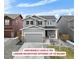 Charming two-story home boasts a gray facade, a well-manicured lawn, and a spacious two-car garage at 27674 E 7Th Dr, Aurora, CO 80018