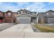 Charming two-story home with a gray exterior, stone accents, and a well-manicured front yard at 27674 E 7Th Dr, Aurora, CO 80018