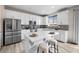 Modern kitchen features white cabinets, stainless steel appliances, and center island with seating at 27674 E 7Th Dr, Aurora, CO 80018