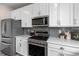 Well-equipped kitchen with stainless steel appliances, gray backsplash, and white countertops at 27674 E 7Th Dr, Aurora, CO 80018