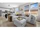Open-concept living room features a large sofa, natural light, and stylish decor at 27674 E 7Th Dr, Aurora, CO 80018