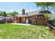 Backyard view of the brick home with well-maintained lawn and a concrete patio perfect for outdoor entertaining at 4720 S Grant St, Englewood, CO 80113