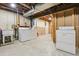 Basement laundry area with washer, dryer, and utility sink, with open access to unfinished space at 4720 S Grant St, Englewood, CO 80113