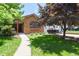 Charming brick home featuring a well-maintained lawn and a cozy front porch entry at 4720 S Grant St, Englewood, CO 80113