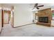 Cozy living room featuring a classic brick fireplace, neutral carpet, and ceiling fan at 4720 S Grant St, Englewood, CO 80113