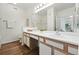 Bright bathroom with wood-look floors, a white vanity, and a large mirror over the vanity at 7489 S Quail Cir # 814, Littleton, CO 80127