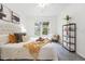 Bright bedroom featuring a large window, neutral colors, a comfortable armchair, and decorative shelving at 7489 S Quail Cir # 814, Littleton, CO 80127