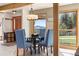 Cozy dining room with a round table, comfortable blue chairs, and a view of the surrounding landscape at 4948 Cameyo Rd, Indian Hills, CO 80454